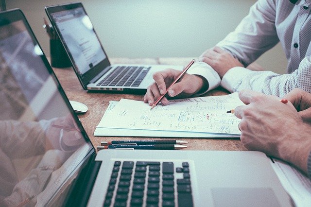 To mennesker sidder ved et skrivebord ved deres computere og arbejder med SEO