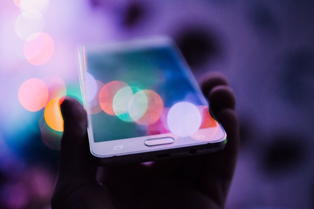 En Iphone holdes op for at symbolisere et device, hvor den digitale kommunikation også foregår på